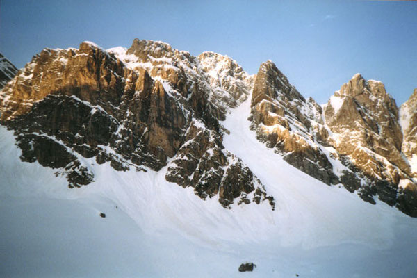 un canalone innevato sulla destra risale piegando verso destra