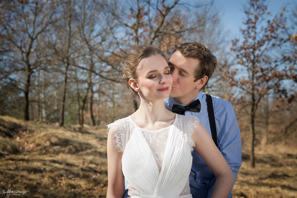 Bräutigam küsst Braut auf Wange