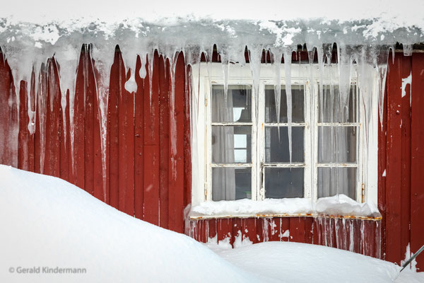 Eiszapfen an einem typischen Holzhaus