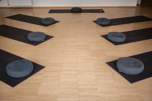 Kursraum mit Matten und Yoga-Kissen