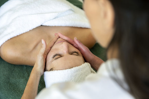 Kosmetikerin während einer Gesichtsmassage einer jungen Frau
