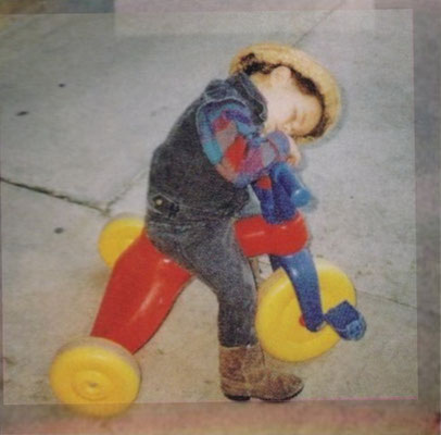 Nick taking a nap on his tricycle.
