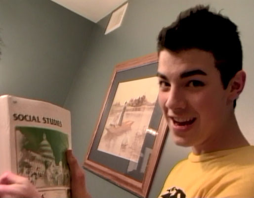 Showing feeling his schoolwork, holding up his pack of 10th Grade Social Studies ACE Paces - From the 2006 Day in the Life video