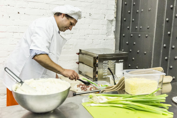 Ein erfahrener Koch vor dem Flammkuchen-Ofen – bereit, köstliche Kreationen zu zaubern!