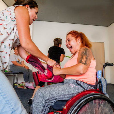 Ein Frau im Rollstuhl kämpft mit einer Frau die steht.