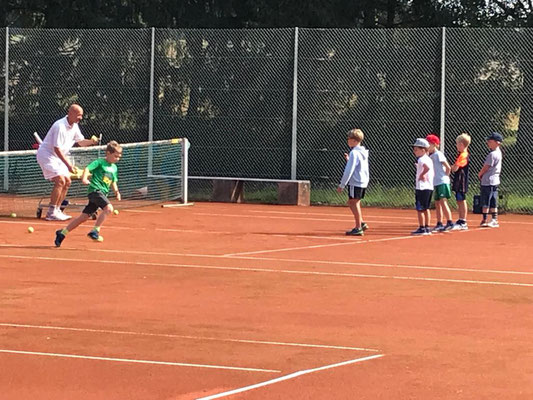 Kinder lernen die Abläufe auf einem Tennisplatz