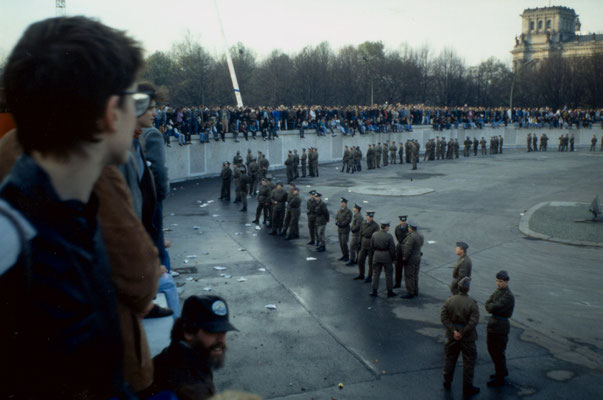 The day before the Berlin Wall fell: West-Berliners occupy the wall, confronted with East-German soldiers, 1989.