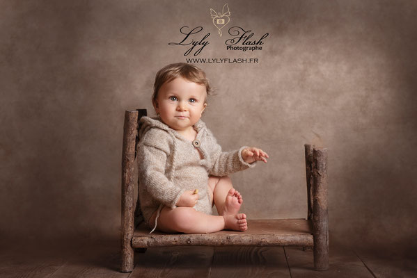 portrait de bébé en studio photo. Photo bébé par photographe lylyflash sur son lit en bois