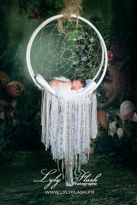 photo de naissance original pour un bébé dans une suspension et un décor nature et féerique pour une séance naissance du nouveau-né incroyable
