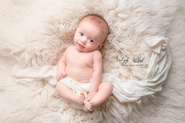 séance photo naissance pour bébé près de photographe Marseille sur un tapis douillé bébé est mis en valeur