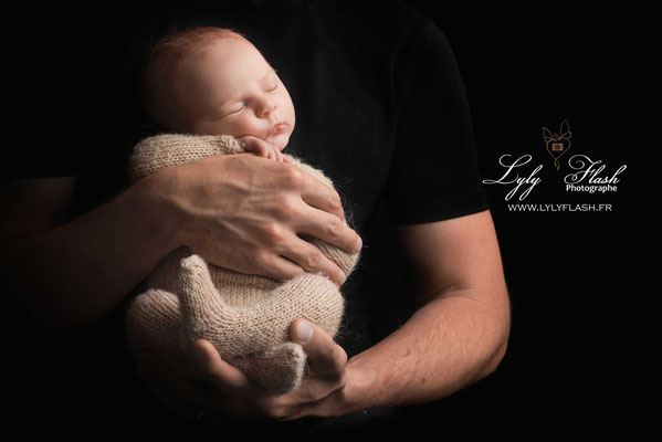 photo d'un nouveau-né dans les mains de son papa par lyly flash photographe nouveau-né