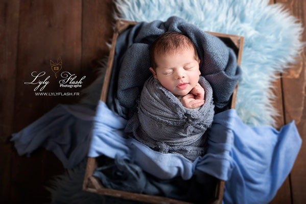photo bébé garçon dans de celle couleur bleu et son beau panier par la photographe naissance