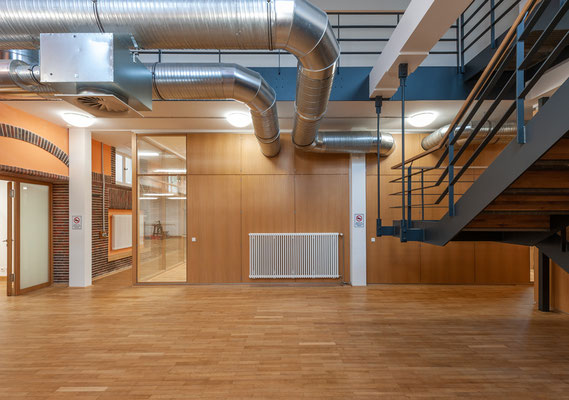 Sanierung und Umnutzung einer historischen Turnhalle zum Nachwuchsleistungszentrum, Foyer mit lufttechnischen Anlagen und Treppe