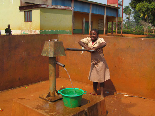 Schülerin beim Wasserholen (Brunnen durch Spenden finanziert)