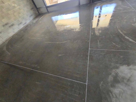Réalisation d'un sol industriel avec finition quartz gris et joints blancs pour des locaux d'activités à toulouse.