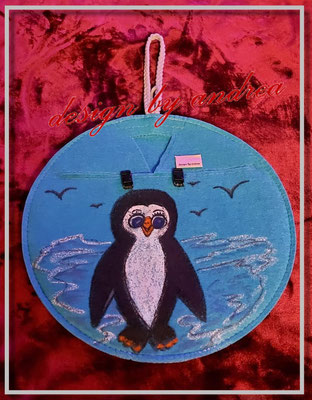 Beutelverstecker in türkis mit schwarzen Klickverschlüssen und handgemalten "Pinguin-Motiv"