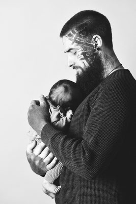 Vater hält sein Baby vor hellem Hintergrund, natürliche Babyfotografie in Villach