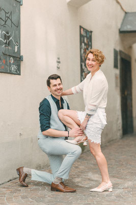 Hochzeitspaar in spielerischer Pose in einer schmalen Gasse, urbane Hochzeitsfotografie.