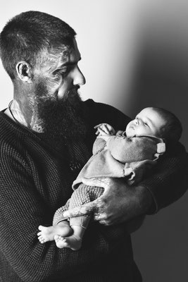 Vater blickt sein Baby ruhig an, schwarzweiße Babyfotografie in Villach