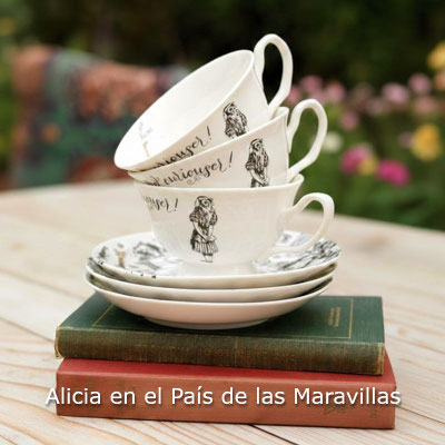 juego de tazas de té de porcelana blanca con ilustraciones de Alicia en el País de las Maravillas y la frase "Curiouser and Curiouser", apiladas sobre libros antiguos en una mesa de madera exterior
