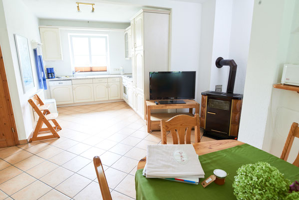 Offene Küche und Wohnbereich mit Holzofen der Ferienwohnung "Monika" auf dem Imkershof der Familie Röhrs in Schneverdingen-Surbostel