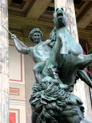 Bronzestatue des Löwenkämpfers vor dem Säuleneingang des Alten Museums. Die Skulptur stellt einen Mann dar, der mutig von seinem Pferd herab gegen einen Löwen kämpft. Er stellt den Triumph des Menschen gegen die Wildnis dar. Standort: Lustgarten.