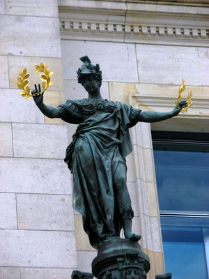 Bronzestatue der römischen Siegesgöttin Victoria mit goldfarbenen Lorbeerkränzen in den Händen. Der Lorbeer gilt seit der Antike als Symbol des Siegers, als Glücksbringer aber auch als Machtsymbol. Standort: Reichstagsgebäude.