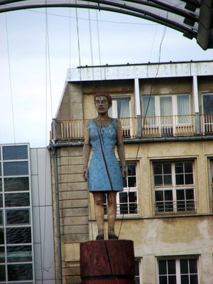 Frauenfigur der drei «Torwächter» von Stephan Balkenhol. Sie steht wie die beiden anderen Wächter auf einem hohen Baumstamm und sieht scheinbar regungslos in die Ferne. Standort: Karl-Liebknecht-Straße.