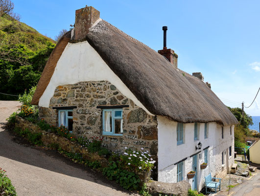 Sehenswürdigkeiten Cadgwith: Ein in den Hang gebautes altes Steinhaus mit Reetdach. Charakteristisch sind die typisch britischen Kamine.