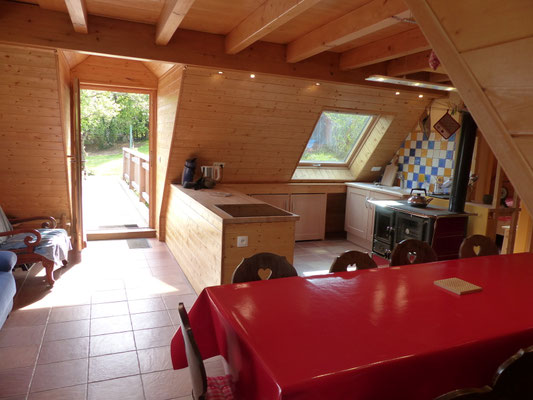 vue de la pièce à vivre avec le coin cuisine et l'entrée par la passerelle 