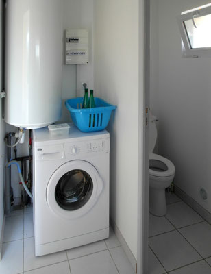 lave-linge dans un pas-perdu, à côté des toilettes séparées