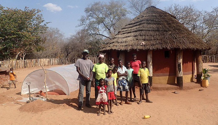 Village Head Douglas Ncube with his family next to their new biogas unit