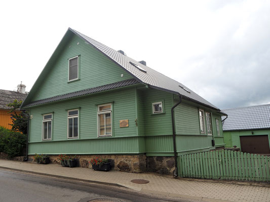 altes Holzhaus auf schiefer Straße