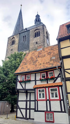 kleines Privathaus vor großer Kirche