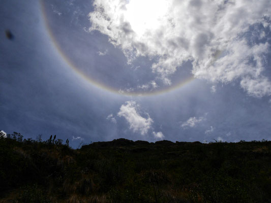 Überraschung! An meinem Poncho kann man erkennen, das es zeitweise Schauer gab. Jetzt sehen wir oben im Himmel einen kreisrunden Regenbogen!