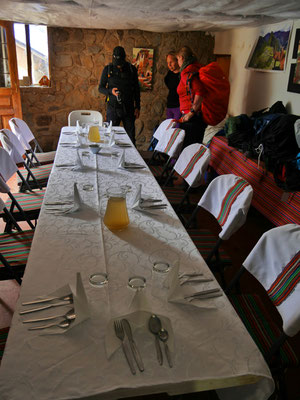 Der Tisch ist gedeckt! Und wie nett! (Aber kein Licht, also essen bevor es dunkel wird...)   Hinten an der Wand treffen wir ein Mitglied des Sendero Luminoso (Scherz).