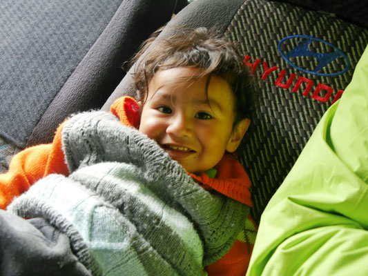 Der kleine Sohn von einem der Fahrer und seine Frau kommen mit. - Wenn ich das Gesicht nur ein wenig verziehe, kann er sich nicht mehr halten vor Spaß.