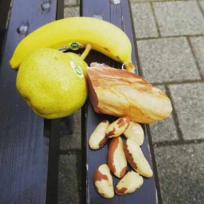 Mittagessen auf einer Parkbank (geräucherte Schweinelende, Birne, Banane, Nüsse)