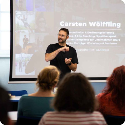 Experte für betriebliche Gesundheitsförderung leitet einen Workshop zur Mitarbeitergesundheit in Leipzig.