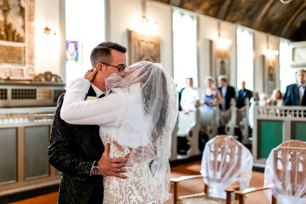 küssendes Brautpaar nach der Trauung in der Kirche von Hamburg Allermöhe