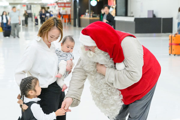 成田空港でサンタクロースと記念撮影をする家族