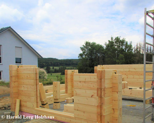 ... und die ersten schweren Lamellenbalken des Holzhauses in echter Blockbauweise wurden mit Hilfe eines Krans montiert