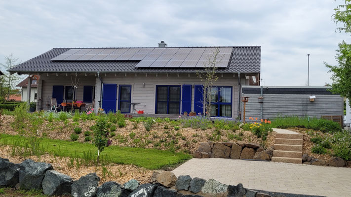 In Finnland produziertes, individuelles Blockhaus mit blauen Fenstern und Fensterläden in Hessen 