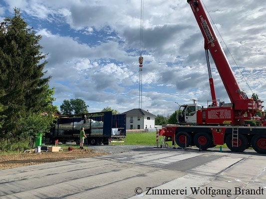 Blockhausbau - Autokran auf der Blockhaus Baustelle   