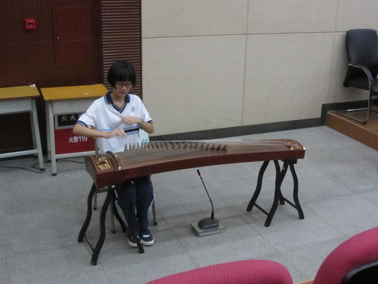 Musikalische Darbietung von Schülerinnen der Schule auf einem klassischen chinesischen Saiteninstrument.