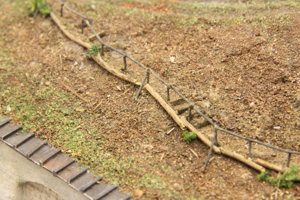 01.10.2013  Einige Stufenbretter aus gebeiztem Furnier ergänzen das Bild. Zur Abfangung des Weges wurden auf der Bergabseite Rundhölzer mit Eisenstäben platziert.