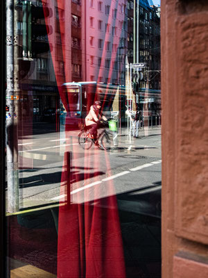 Leere Münchener Straße durch eine spiegelnde Fensterscheibe gesehen