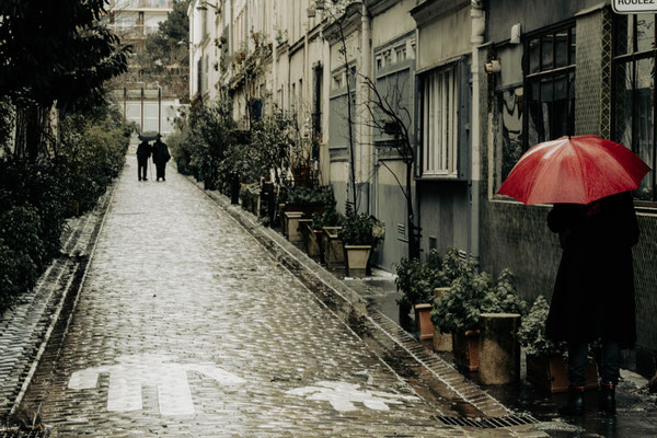 Ruelle pluvieuse et silhouettes floues
