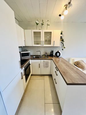 Moderne, voll ausgestattete Küche der Ferienwohnung „Auszeit Niedersfeld“ mit heller Front, Holzarbeitsplatte und stilvollen Details. Hier finden Gäste alles für die Selbstverpflegung – funktional, hochwertig und geschmackvoll eingerichtet.