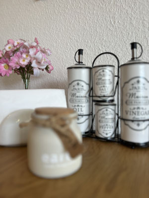 Liebevoll arrangierte Küchendeko in der Ferienwohnung „Auszeit Bergliebe“ mit Gewürz- und Ölspendern im Vintage-Stil, Kerze im Glas und frischen Blumen – ein charmantes Detail, das Gemütlichkeit und Stil vereint.